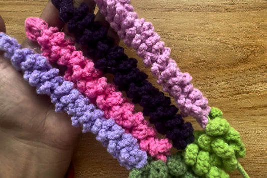 Colorful crocheted headbands on a wooden surface