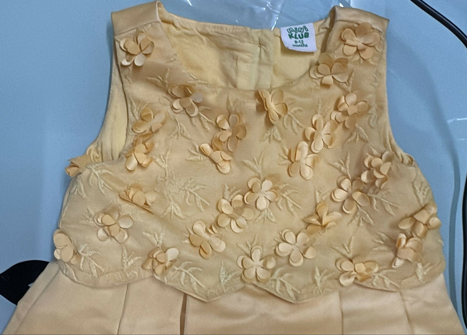Beige floral embroidered garment on a light blue background