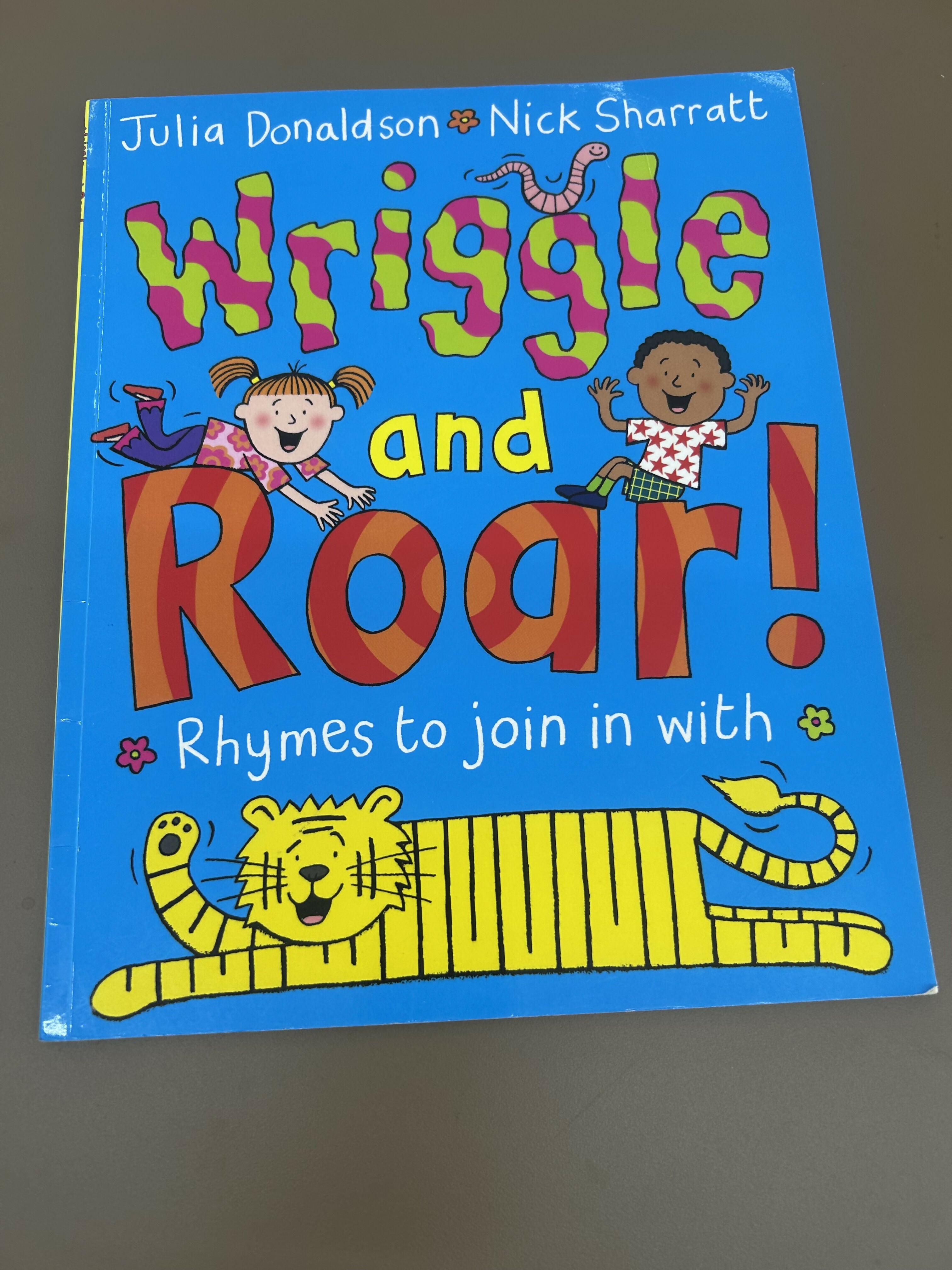 Children's book titled 'Wriggle and Roar!' with colorful text and illustrations
