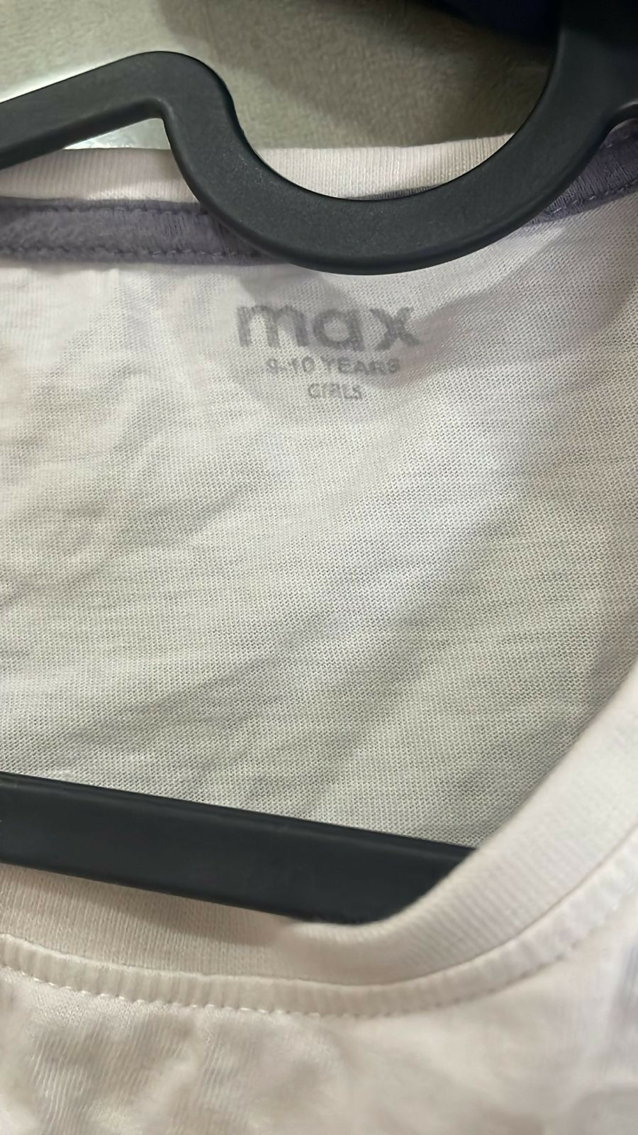 Children's white shirt with 'max' branding on a hanger