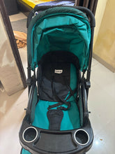 Teal and black stroller on a tiled floor