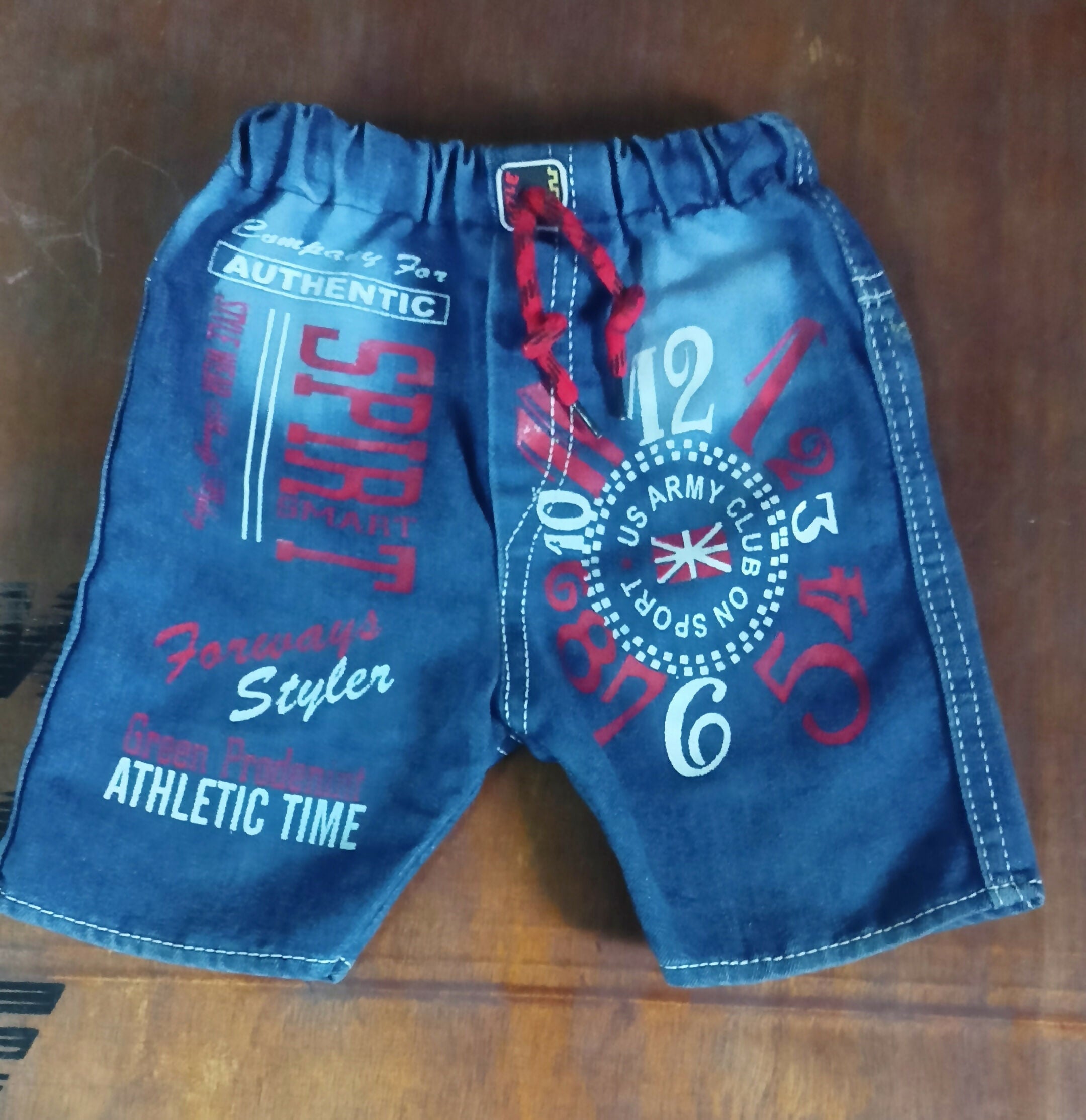 Blue shorts with text and numbers on a wooden surface