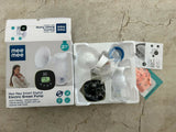 Mee Mee electric breast pump set with packaging on a concrete surface
