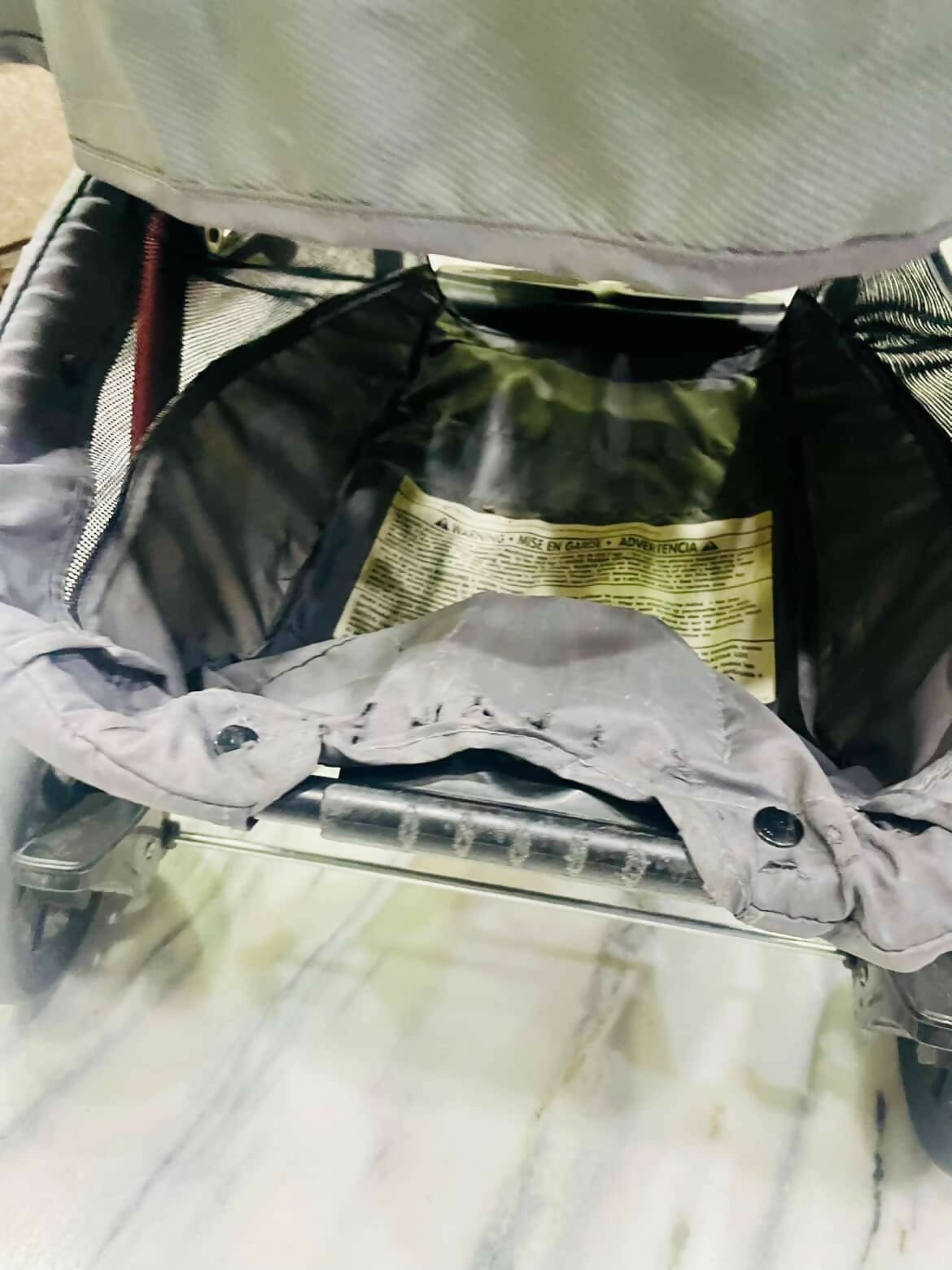 Open suitcase with clothes and a map on a marble surface