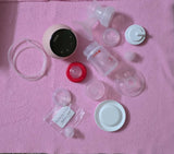Breast pump parts and accessories on a pink surface
