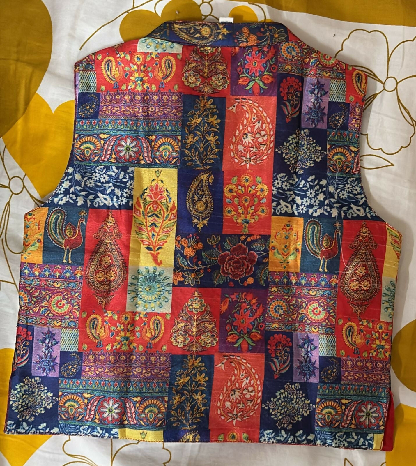 Colorful patchwork vest on a white and yellow floral background
