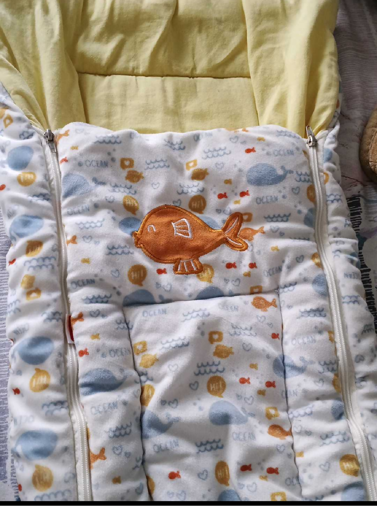 Baby blanket with cartoon fish design on a yellow background