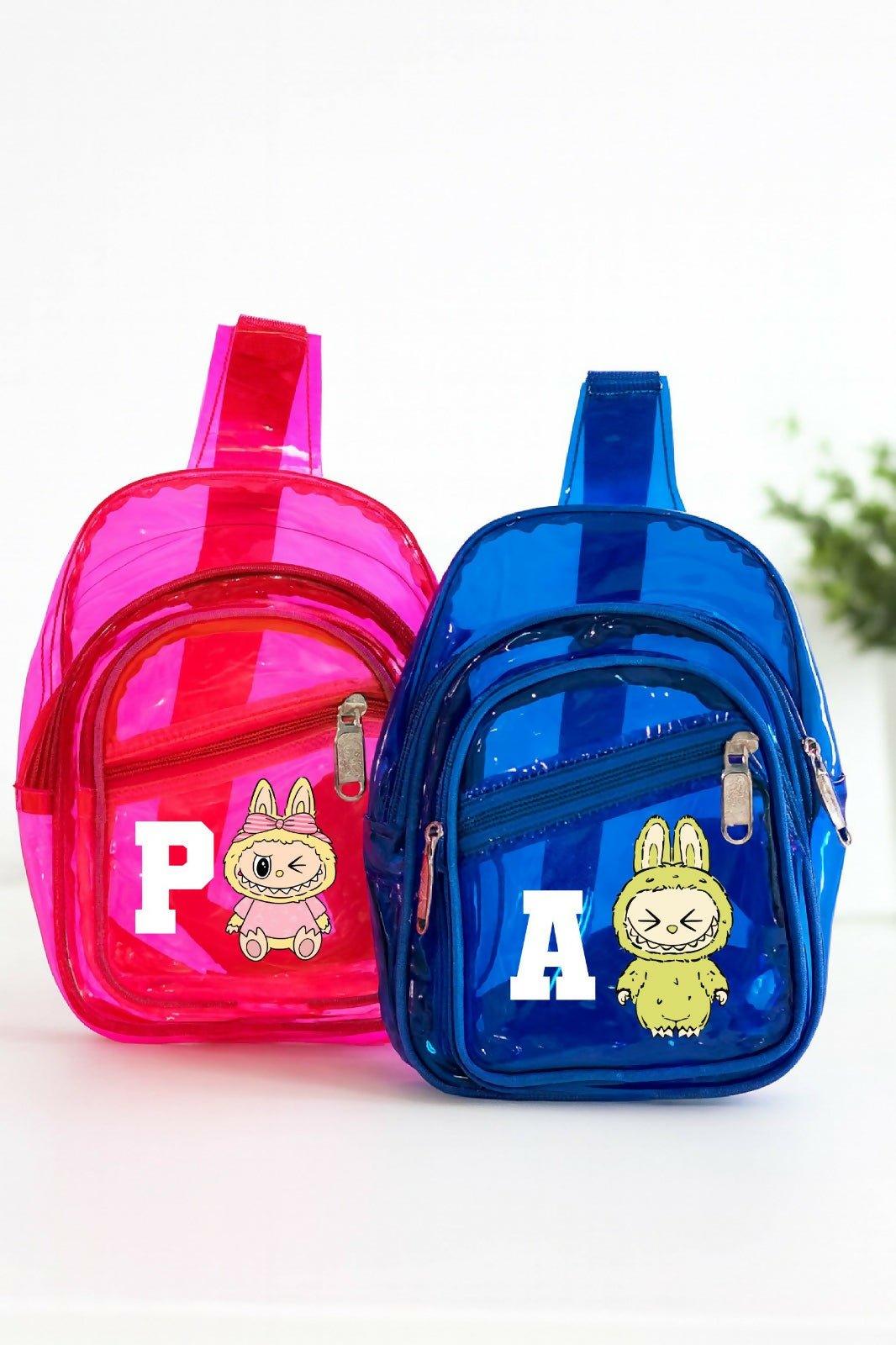 Pink and blue transparent mini backpacks with cartoon characters on a white background