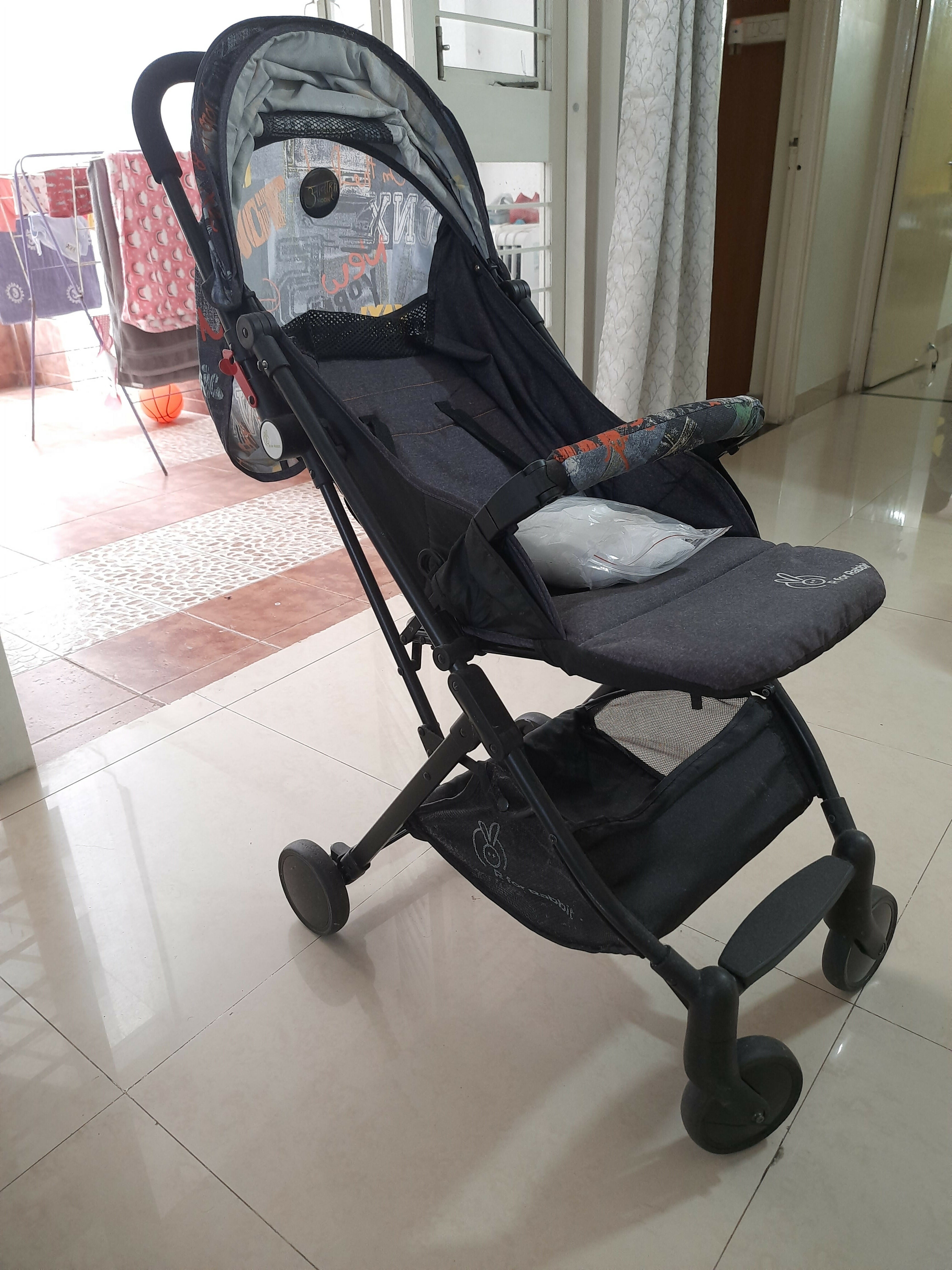 Black stroller on a tiled floor with a blurred background