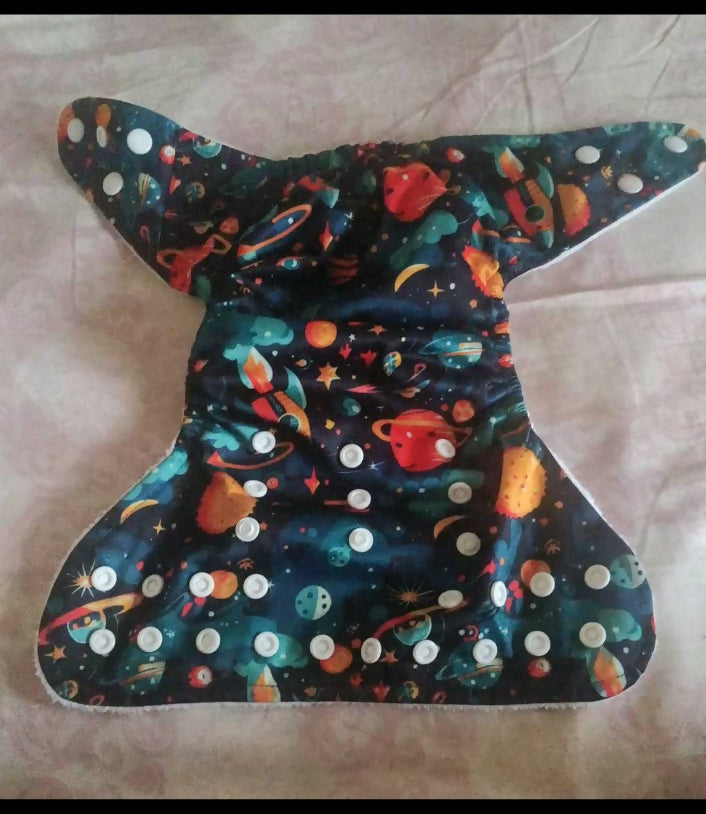 Space-themed diaper cover with planets and stars on a plain background