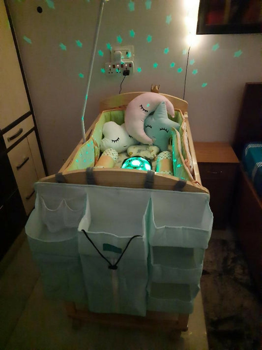 Baby crib with plush toys and a white cover in a room setting.