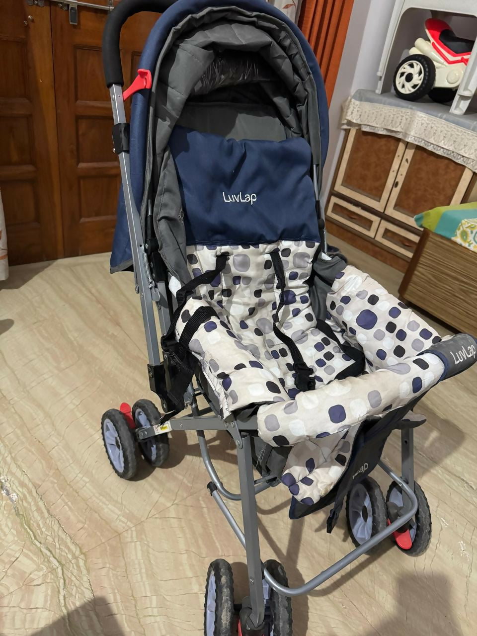 Stroller with a patterned cover on a wooden floor