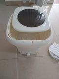 White and beige portable washing machine on a tiled floor