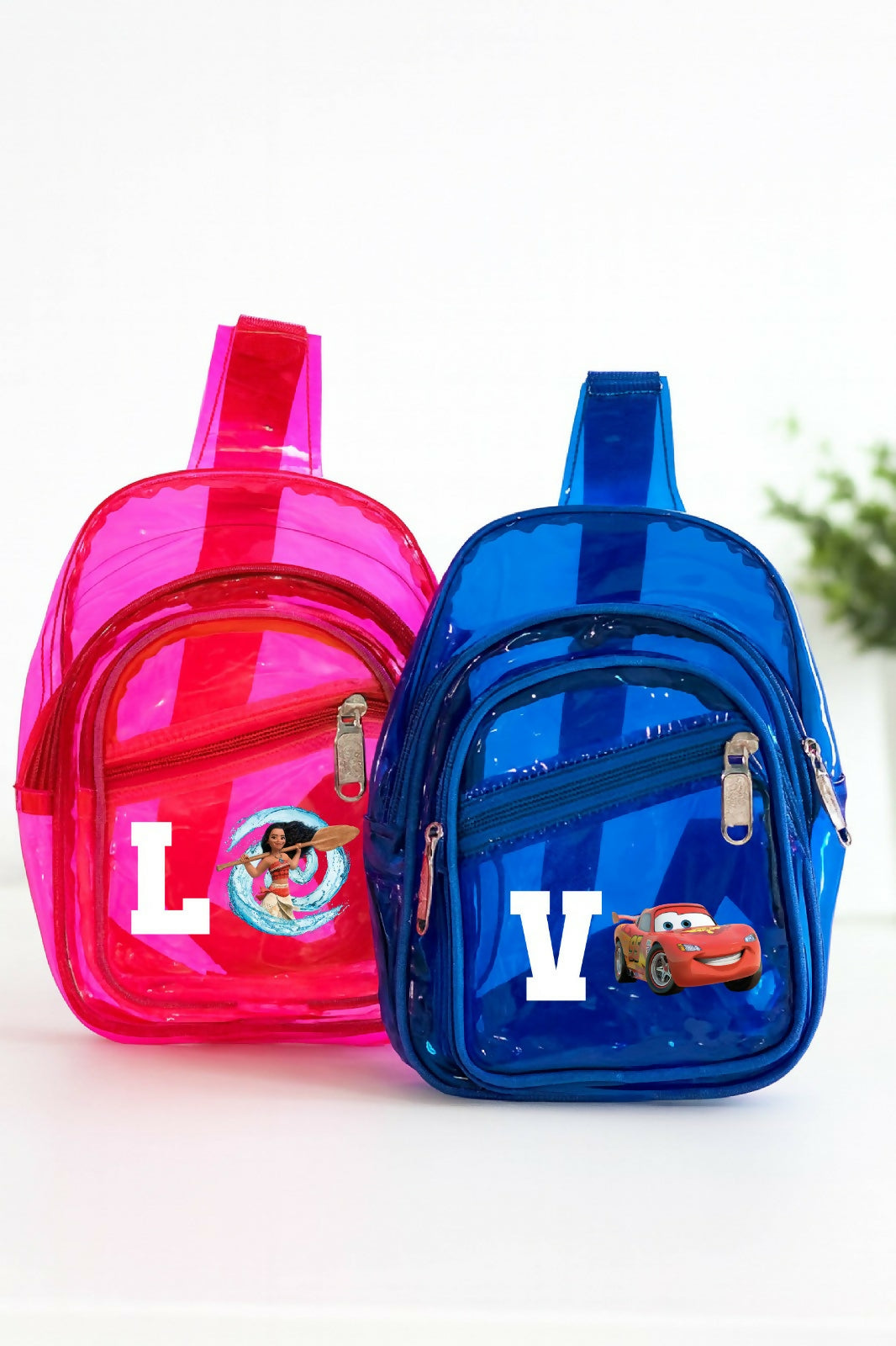 Pink and blue transparent backpacks with cartoon characters on a white background