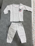 Gray baby outfit with long-sleeve top and pants on a textured surface