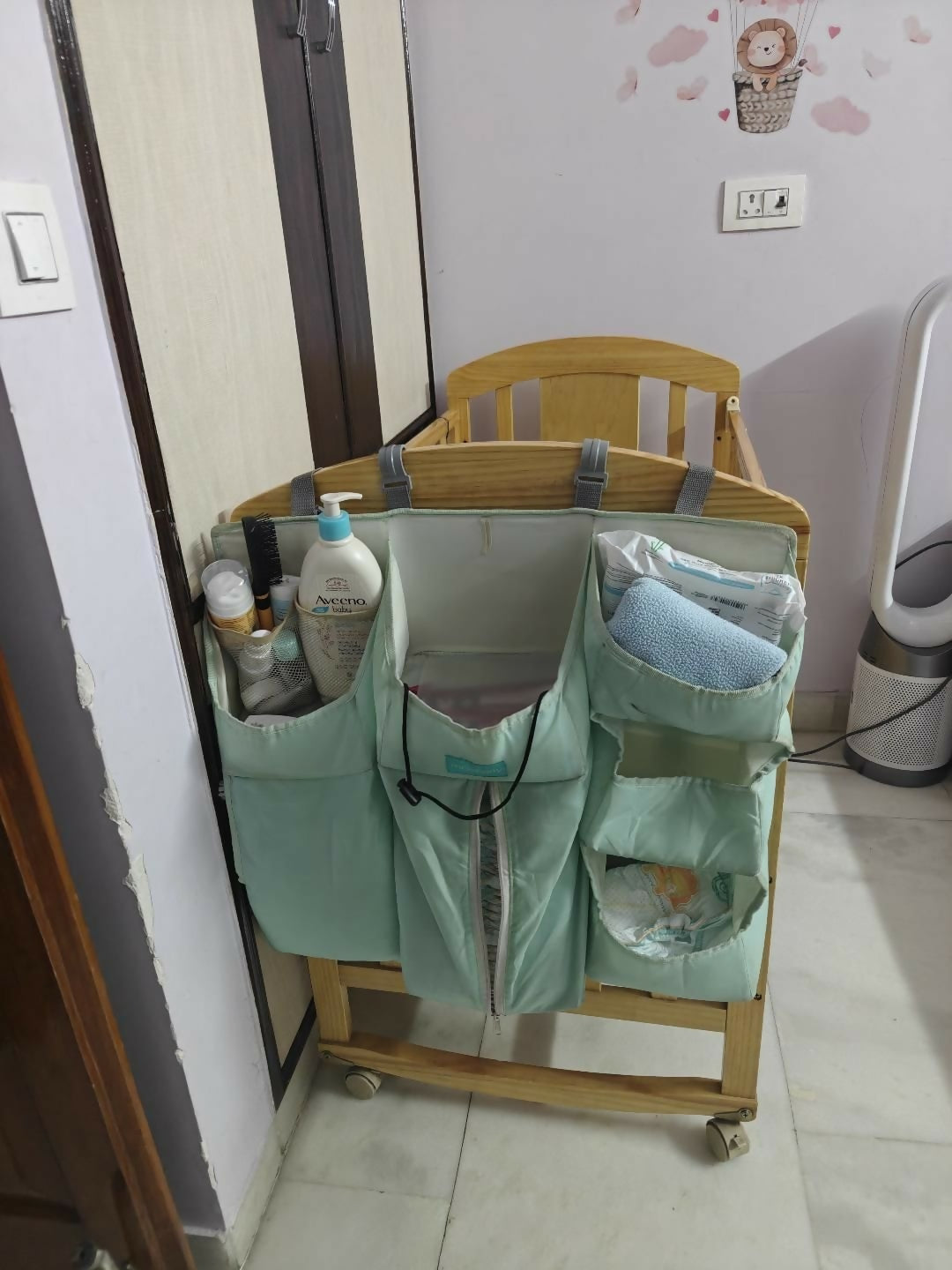 Baby changing station with shelves and pouches in a room setting