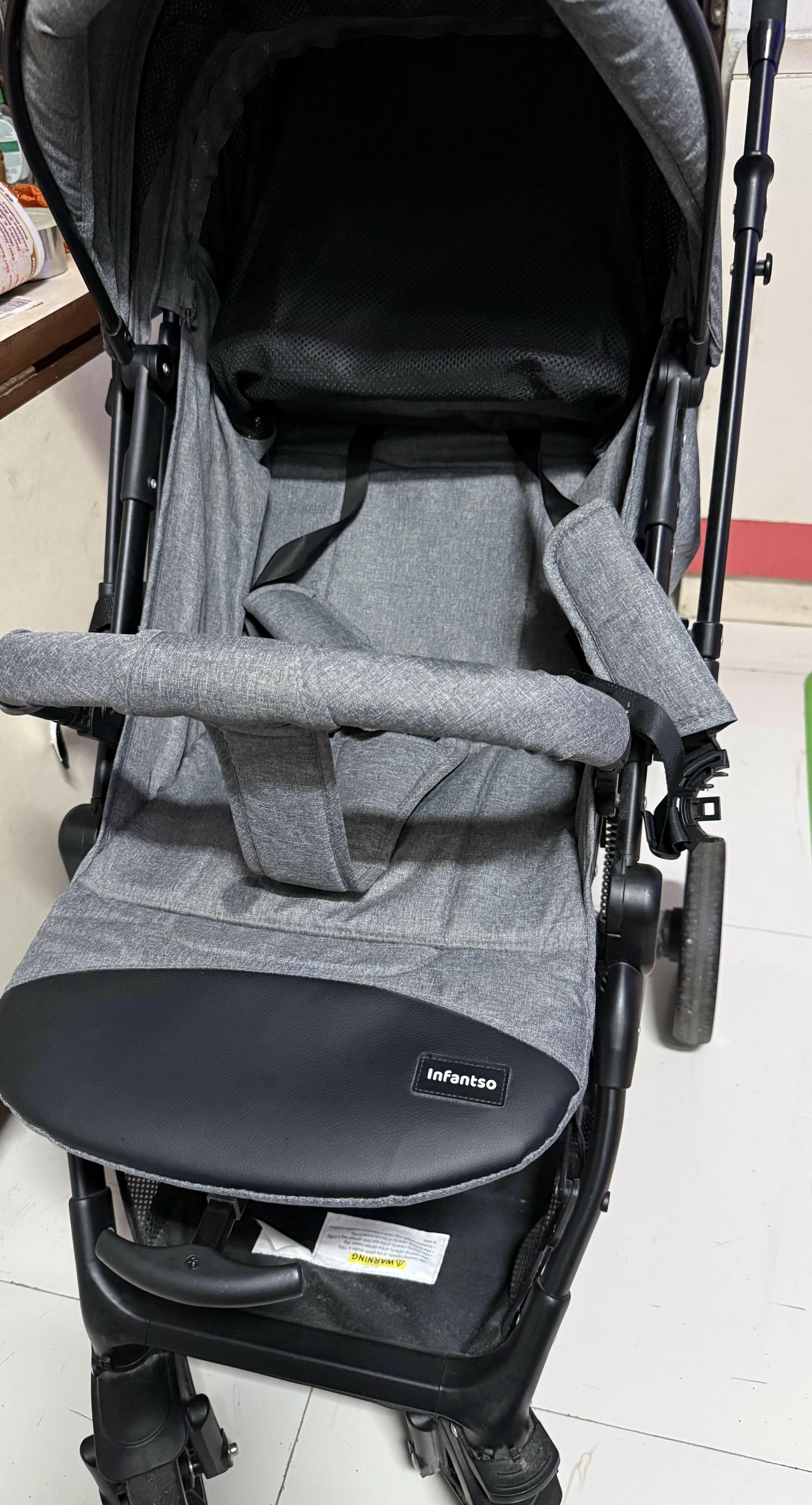 Gray stroller with a visible brand logo on a white floor.
