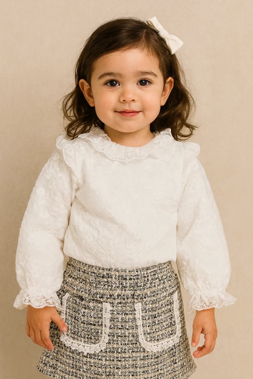 Young girl wearing a white blouse with ruffled details and a patterned skirt