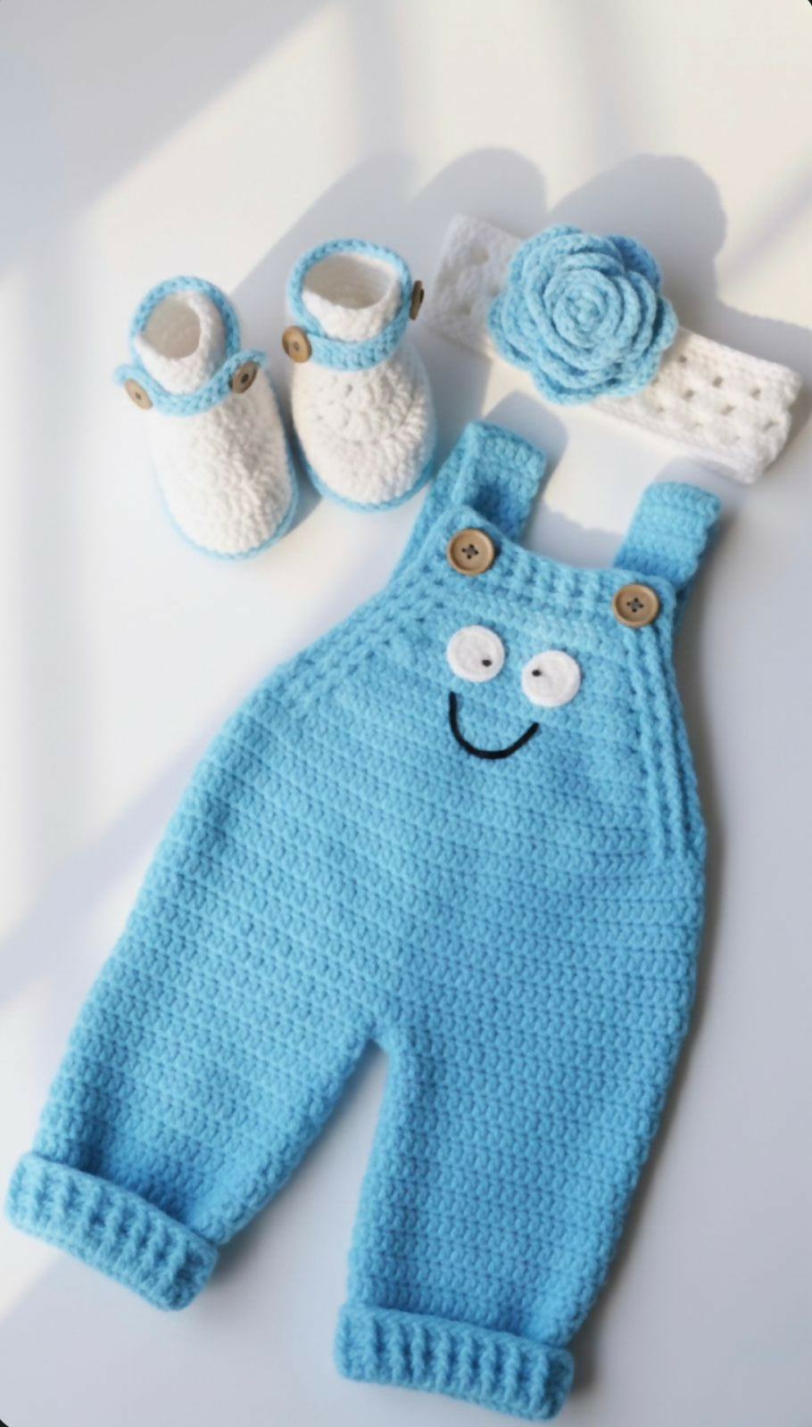 Knitted blue baby romper , white booties, and flower 