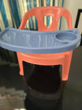 Red plastic chair with a blue tray on a dark background