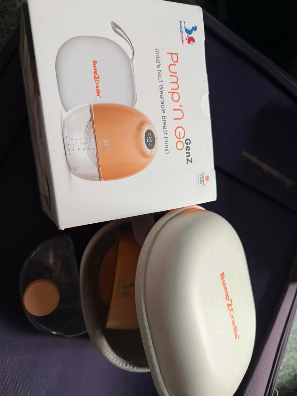 Breast pump with packaging on a dark surface