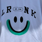 White t-shirt with black text and a green smiley face design 
