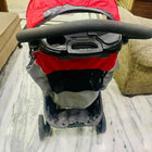 Red and gray stroller on a marble floor