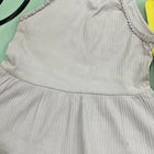 Light gray dress with ruffled straps on a green background