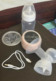 Breast pump with accessories on a dark surface