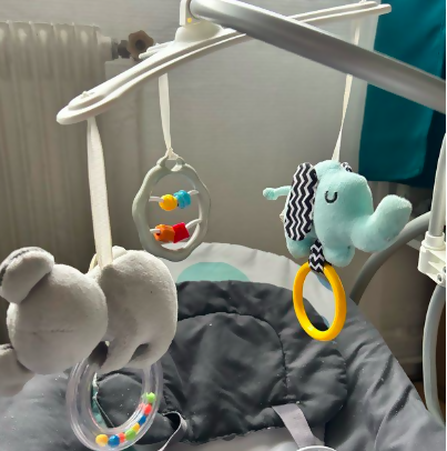 Baby crib mobile with plush toys and hanging rings on a crib