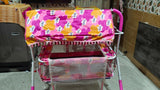 Children's toy cart with colorful floral and polka dot fabric cover in a room setting.