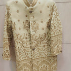 Embroidered traditional outfit on a hanger against a light background