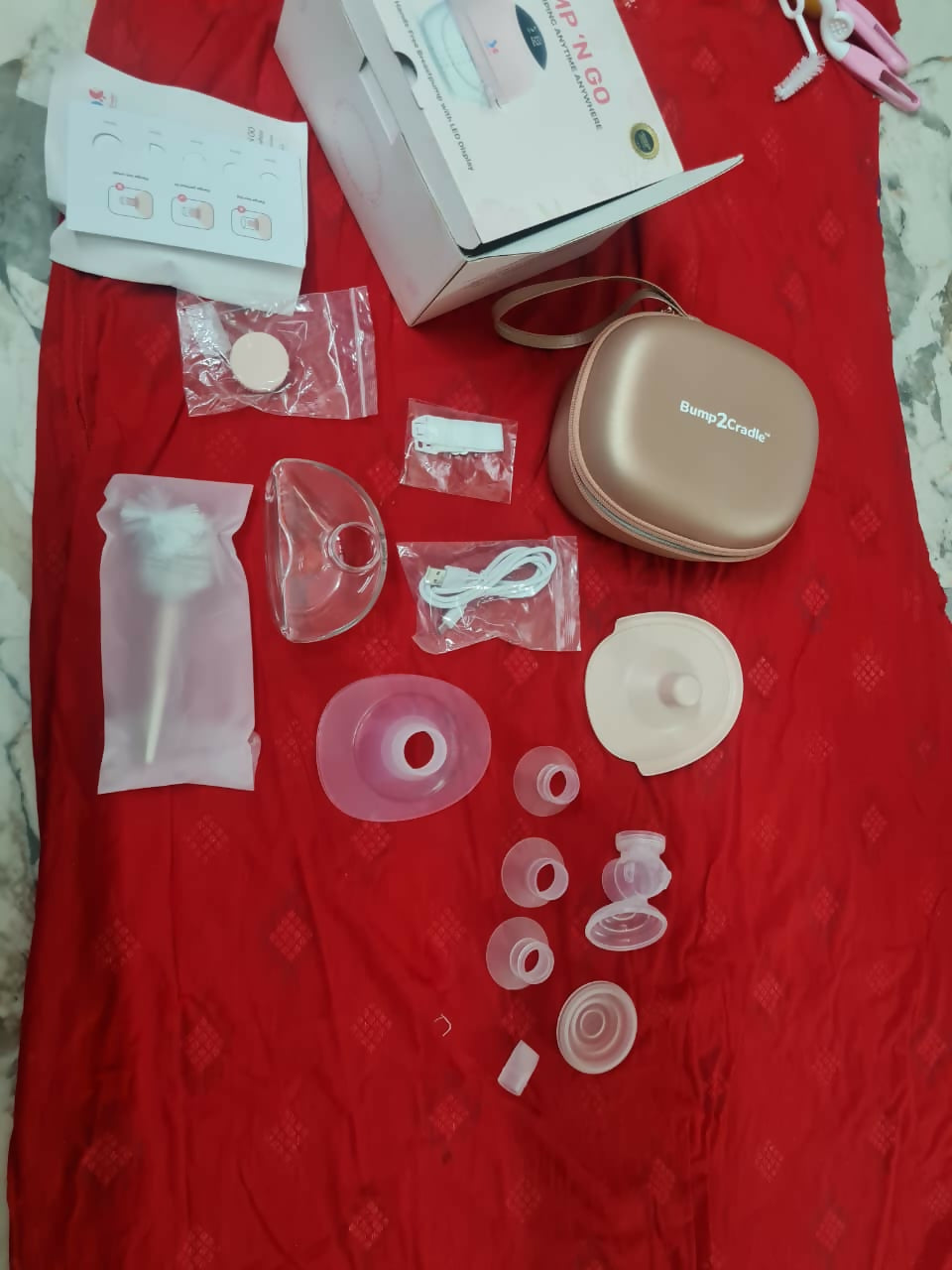 Breast pump parts and accessories on a red surface