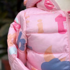 Close-up of a pink children's jacket with colorful letters and shapes.