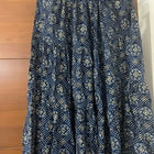 Blue patterned dress on a hanger against a wooden door background