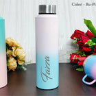 Gradient water bottle with 'Faizza' branding on a wooden surface with flowers.