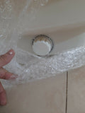 Control knob on a white surface with bubble wrap, hand visible