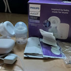 Philips Avent baby bottle and accessories on a wooden floor