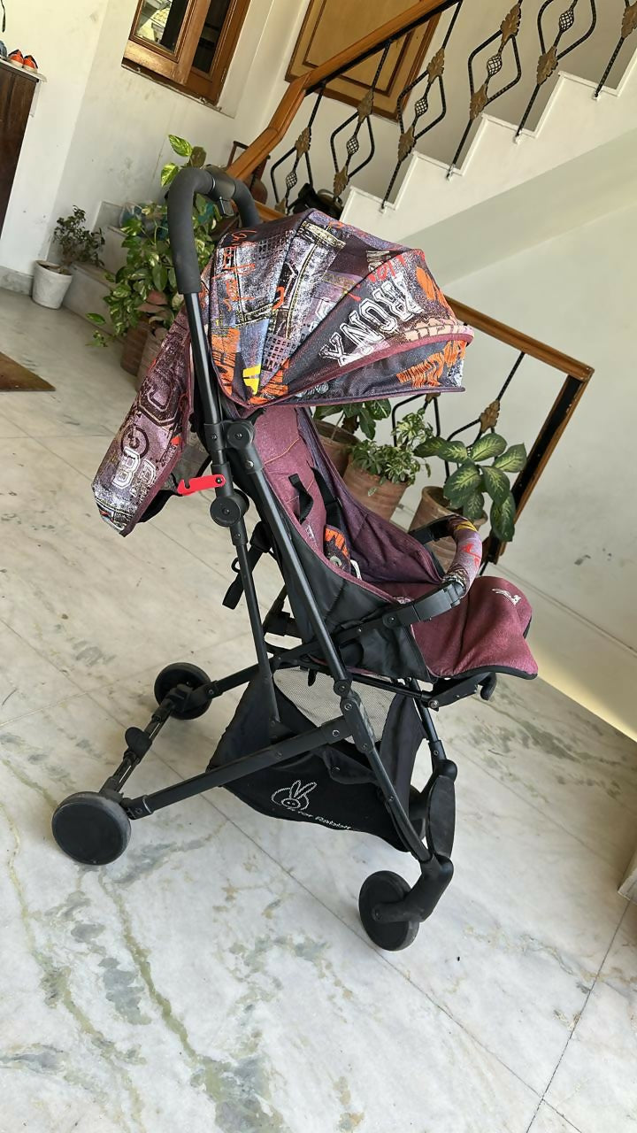 Child's stroller with colorful canopy on a marble floor