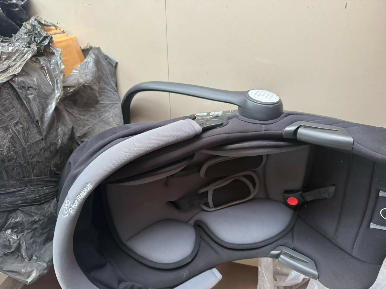 R FOR RABBIT Baby Carry Cot/Car Seat with an ergonomic carry handle, 5-point safety harness, side-impact protection, soft padded seating, and lightweight design for safe and comfortable travel with newborns and infants.