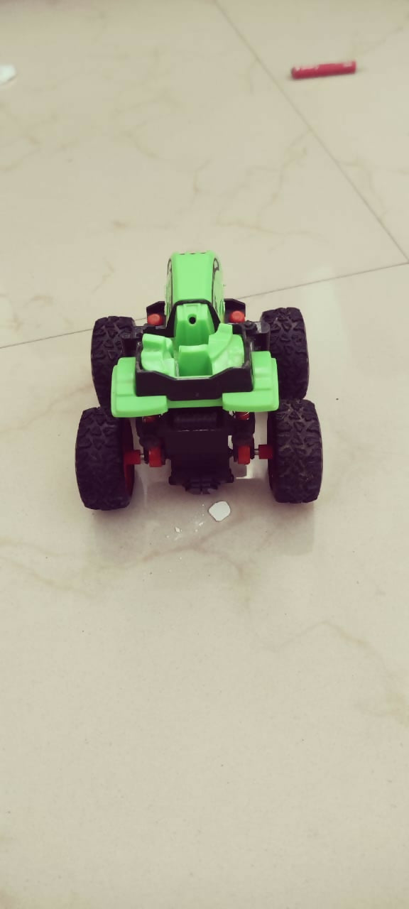 Toy car with green body and black wheels on a tiled floor