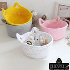 Three woven baskets in yellow, pink, and white 