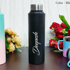 Black water bottle with 'Deepesh' branding on a wooden surface with flowers and other bottles in the background.