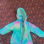 Cozy pastel tie-dye puffer jacket for kids featuring warm padded insulation, a soft lightweight design, front zip closure, and a trendy multicolor pattern for comfortable winter wear.
