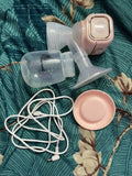 Breast pump with accessories on a floral-patterned fabric background