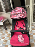 Pink and black patterned stroller on a tiled floor