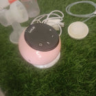 LUVLAP Adore electric breast pump with LUVLAP feeding bottle, adjustable suction settings, compact design, and convenient milk collection support for breastfeeding mothers.