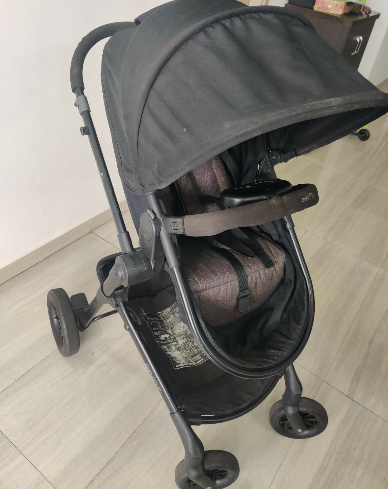 Evenflo travel system with baby stroller and infant car seat, featuring a foldable design, reclining seat, adjustable canopy, 5-point safety harness, and spacious storage basket for convenient travel.