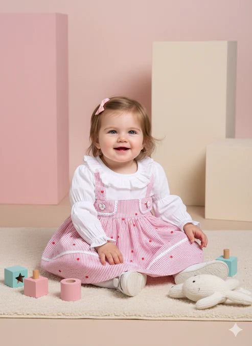 Child wearing a pink checkered dress with white shirt