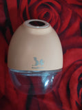 Beige humidifier with a clear water tank on a red floral background